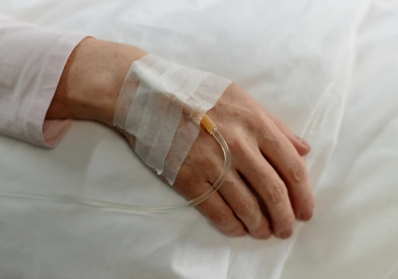 Kroplówki witaminowe Olecko: dłoń z podłączoną kroplówką w spokojnym kadrze