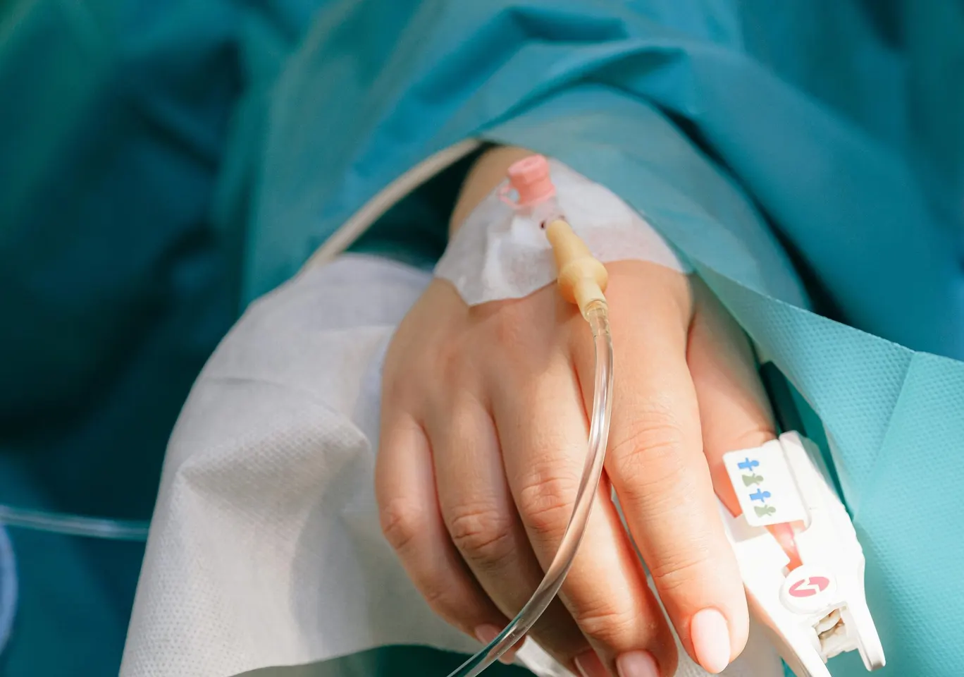Detoks alkoholowy Sejny: dłoń z wenflonem i pulsoksymetrem pod nadzorem