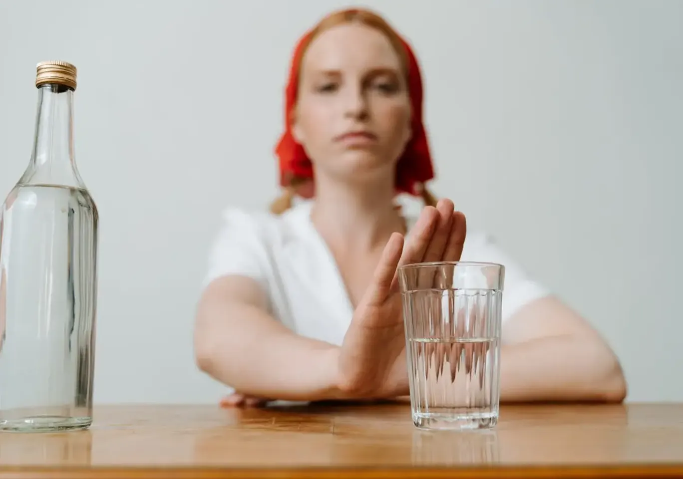 Leczenie alkoholizmu Suwałki: kobieta odsuwa butelkę i sięga po wodę