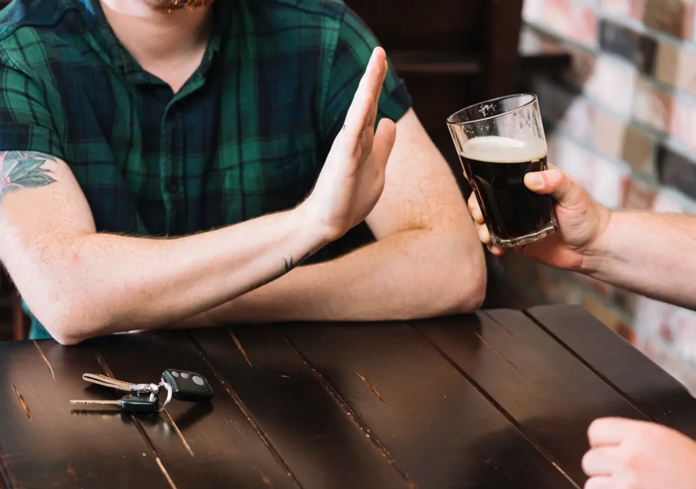 Leczenie alkoholizmu Suwałki: dłoń odmawiająca kufla piwa przy stole